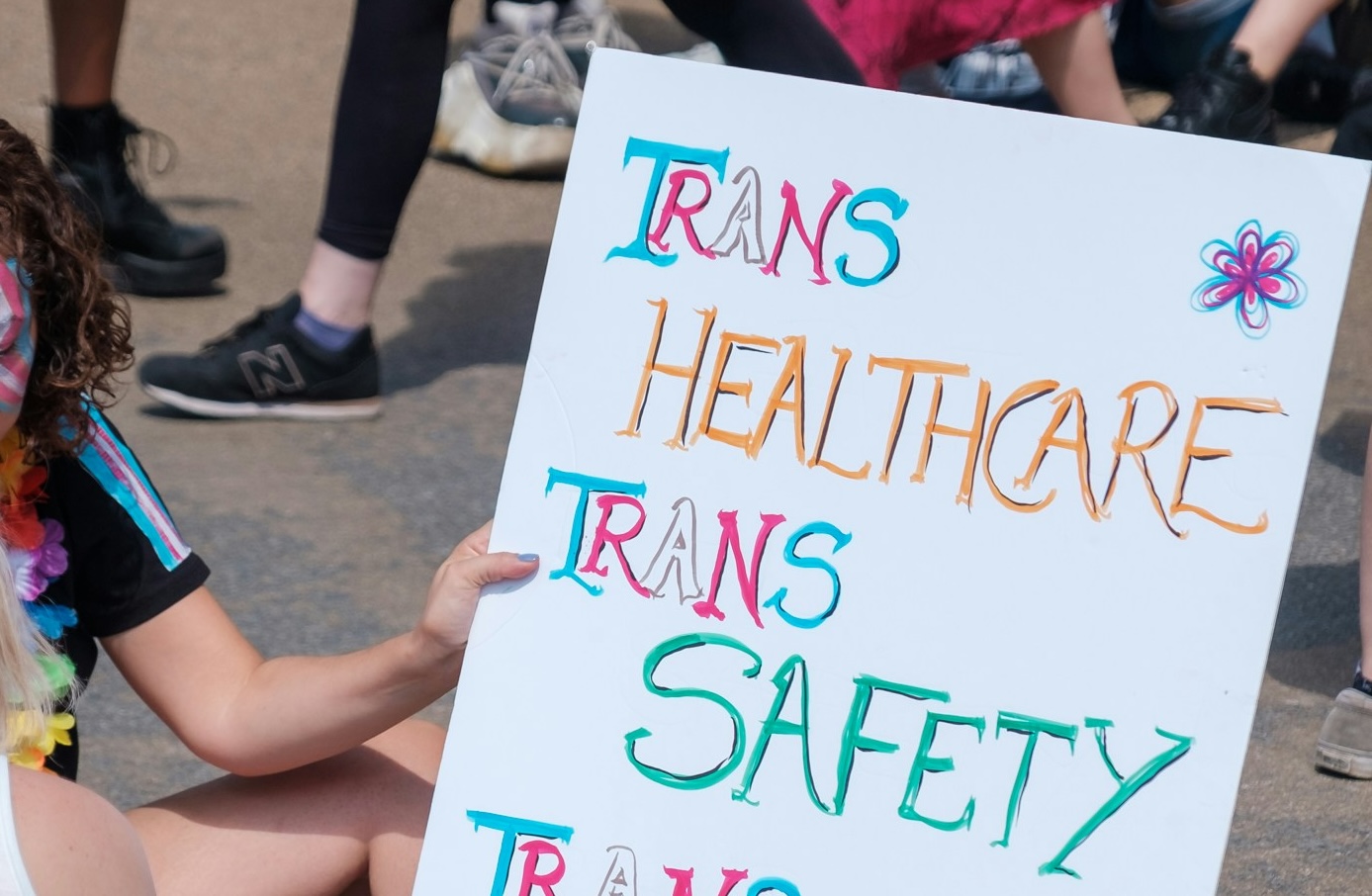 A sign that says "Trans Healthcare, Trans Safety"